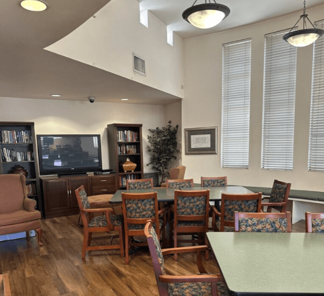 A room with a green table and chairs.